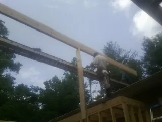 Carpenter setting a ridge beam over a new addition frame — Ice Dam Removal by Roofing Brothers in Huntingdon