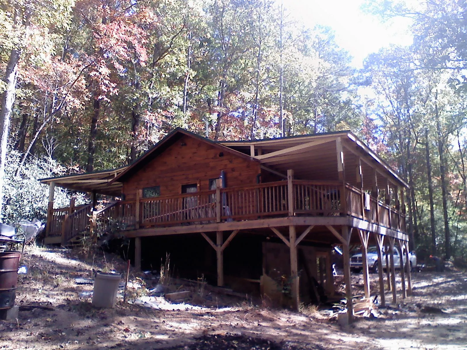 Log cabin with a wraparound porch and metal roof in the fall in Huntingdon